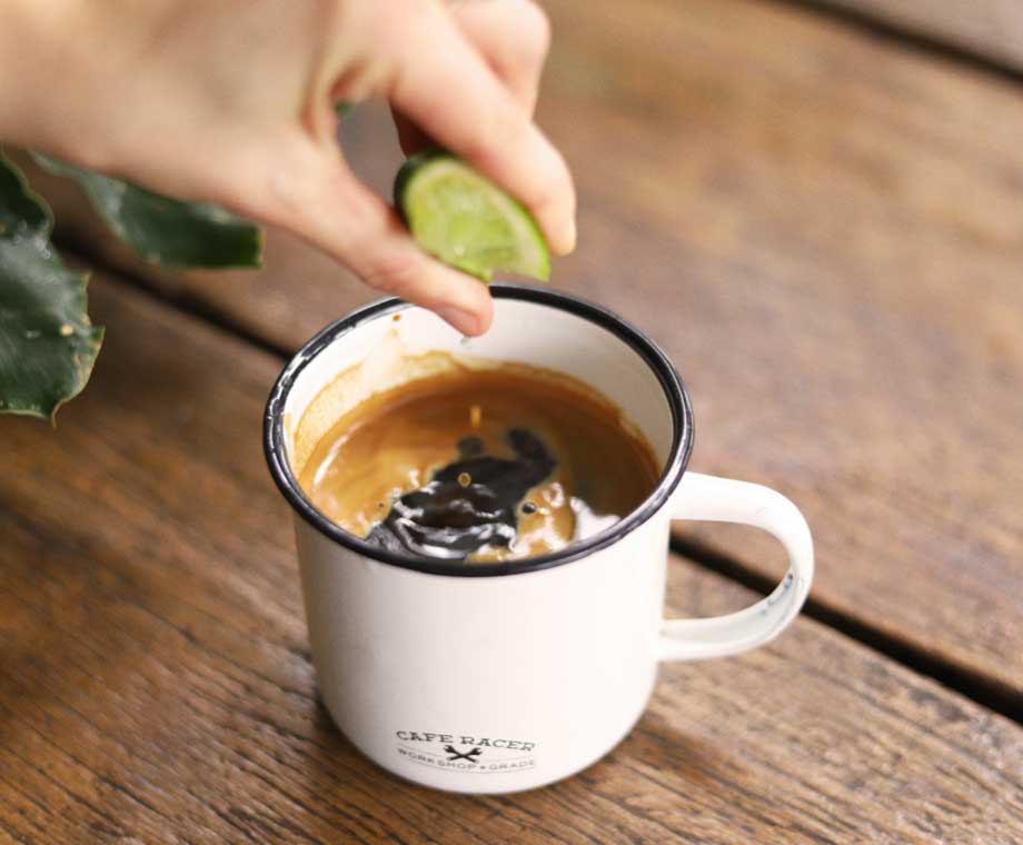 Squeezing lime into PNG coffee